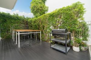 eine Terrasse mit einem Tisch und einem Grill in der Unterkunft Villa Casa Koko - Luxury Modern Minimalism in Thalang