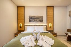 dos cisnes hechos de toallas sentadas en una cama en Villa Mewangi by SooBali Private Pool in Sanur, en Sanur 34 fotos más