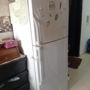 einen weißen Kühlschrank mit Magneten darauf in der Küche in der Unterkunft شقة مفروشة عائلية in Amman