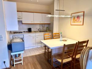 a kitchen with a table and chairs in a kitchen at Dünenschlösschen 22 in Wangerooge