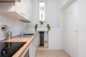 a white kitchen with a sink and a counter at Casa Lusso con 3 Camere con Affaccio Esclusivo su San Petronio in Bologna