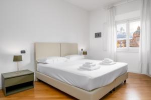a white bedroom with a large bed and a window at Casa Lusso con 3 Camere con Affaccio Esclusivo su San Petronio in Bologna