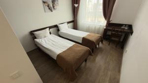 a hotel room with two beds and a desk at Готель Цісар in Lviv +93 photos