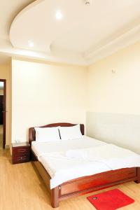 ein Schlafzimmer mit einem großen Bett und einem roten Teppich in der Unterkunft Thiên Hà Hotel in Ho-Chi-Minh-Stadt