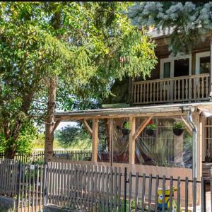 une maison avec une terrasse et une clôture dans l'établissement Pacsirta Vendégház, à Tass