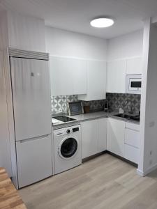 eine weiße Küche mit Waschmaschine in der Unterkunft Plaza del Ayuntamiento -Centro Histórico- in Oviedo