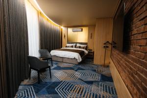une chambre d'hôtel avec un lit et un mur en briques dans l'établissement Samovar, à Petropavlovsk-Kamtchatski
