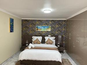 a bedroom with a large bed with floral wallpaper at Fezeu's Place in Johannesburg
