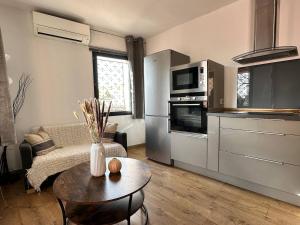 a kitchen and living room with a couch and a table at Chez Tao in Carqueiranne +8 photos