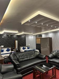 a living room with a leather couch and two beds at Thottunkal Tourist home in Kadavoor