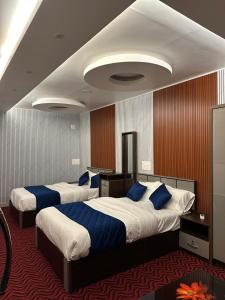 Dos camas en una habitación de hotel con almohadas azules. en Thottunkal Tourist home, en Kadavoor