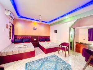 una habitación con una cama y un sofá y una mesa en R mansion, en Calangute