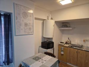 a small kitchen with a table and a sink at The Ozzy Room in Braşov