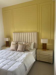 a bedroom with a large white bed with two night stands at The Golfside Luxe in Gonapola