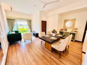 a dining room and living room with a table and chairs at The Golfside Luxe in Gonapola