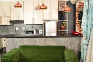 ein grünes Sofa vor einer Küchentheke in der Unterkunft RAMATA GUEST HOUSE in Pretoria