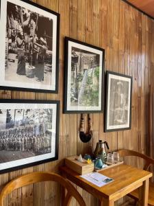 a room with a wooden table with pictures on the wall at SPICE TRADER in Nusa Penida