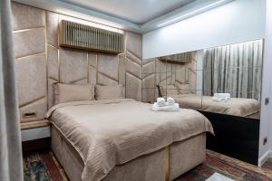 ein Schlafzimmer mit zwei Betten und einem Spiegel in der Unterkunft VNS LUXURY STAY apartment in Târgovişte