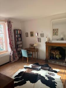 a living room with a cow rug on the floor at Halte dans le Perche 