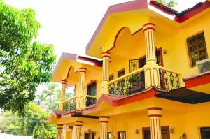un gran edificio amarillo con balcón en R mansion, en Calangute