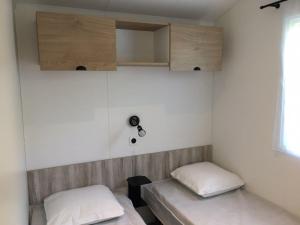 ein Zimmer mit zwei Betten und Holzschränken in der Unterkunft Mobilhome Malaga Climatisé 32 in Saint-Martial-de-Nabirat