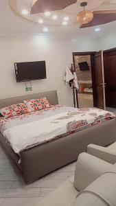 una camera da letto con un letto grande con una TV a parete di Shahnoor cottages Luxury Apartment ad Abbottābād