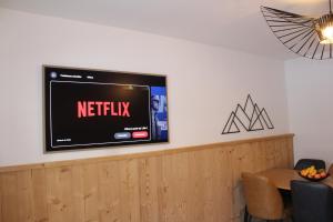 a tv on a wall with a netflix sign on it at Centre, Pistes à pied, Vue magnifique, Calme, Tout renové, Grande terrasse in Les Gets