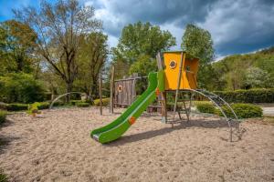 ein Spielplatz mit Rutsche in einem Park in der Unterkunft Mobilhome Agora climatisé 50 in Saint-Martial-de-Nabirat