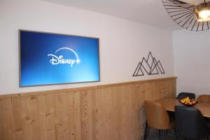 a flat screen tv on a wall above a table at Centre, Pistes à pied, Vue magnifique, Calme, Tout renové, Grande terrasse in Les Gets