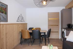 a kitchen and dining room with a table and chairs at Centre, Pistes à pied, Vue magnifique, Calme, Tout renové, Grande terrasse in Les Gets