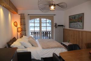 a bedroom with a large bed and a balcony at Centre, Pistes à pied, Vue magnifique, Calme, Tout renové, Grande terrasse in Les Gets +32 photos