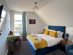 a bedroom with a blue and white bed with yellow pillows at The Linden Leaf Rooms with free car parking in Nottingham