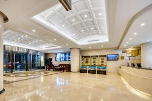 a lobby of a building with a large ceiling at 青岛机场富华酒店 in Qingdao
