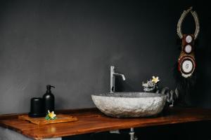 a bathroom with a stone sink on a wooden table at SPICE TRADER in Nusa Penida +18 photos