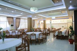 a dining room with tables and chairs in a restaurant at DEA Hotel 2002 in Korçë