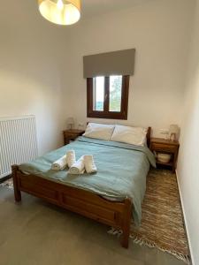 a bedroom with a bed with two towels on it at Pelion Roots in Zagora