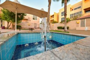 ein Brunnen in der Mitte eines Schwimmbeckens in der Unterkunft Harf-281 4 BEDROOMS - Raha Gardens AD in Abu Dhabi
