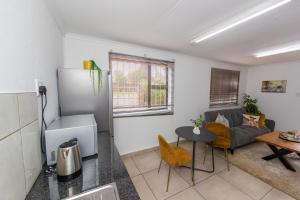a kitchen and living room with a couch and a table at Serenity on Geelhaak in Kempton Park
