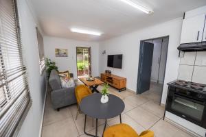 a living room with a table and a couch at Serenity on Geelhaak in Kempton Park