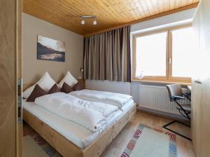 une chambre avec un lit, un bureau et une fenêtre dans l'établissement Haus Gant, à Sankt Gallenkirch