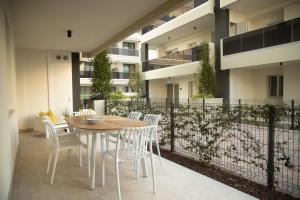 BIA'S Beach - appartamenti fronte mare في بيبيوني: فناء مع طاولة وكراسي وسياج