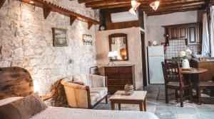 un salon avec un mur en pierre dans l'établissement Agrovino Lofou, à Lófou