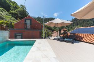 a house with a swimming pool and an umbrella at Avo Maria 2 House by AH in Senhora do Rosário