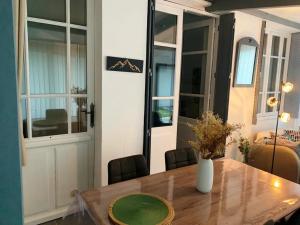 a dining room table with a vase on top of it at Le jardin privatif de Pauze Cauterets wifi et parking gratuits Vue panoramique in Cauterets +56 photos