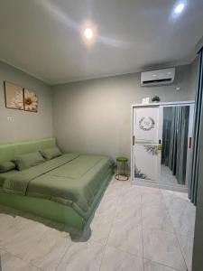 a bedroom with a green bed and a window at Green Love Villa in Pasirmuncang 1