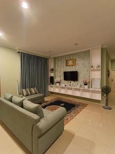 a large living room with a couch and a television at Green Love Villa in Pasirmuncang 1