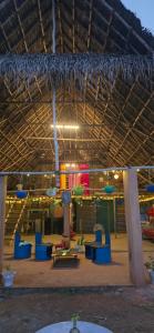Un edificio grande con sillas azules y una mesa en WoodPacker Hostel Pondicherry, en Auroville