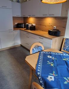 - une cuisine avec une table et une couverture bleue dans l'établissement An-der-Stadtmauer, à Fladungen