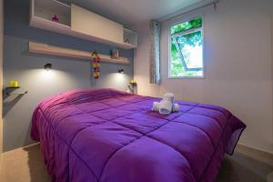 米罗勒Camping - Parc aquatique - eeiccd的卧室配有紫色床,里面装有动物 更多33张照片