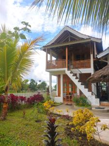 a house with a porch and a staircase in a yard at Tetebatu Flush Harmony in Tetebatu +148 photos